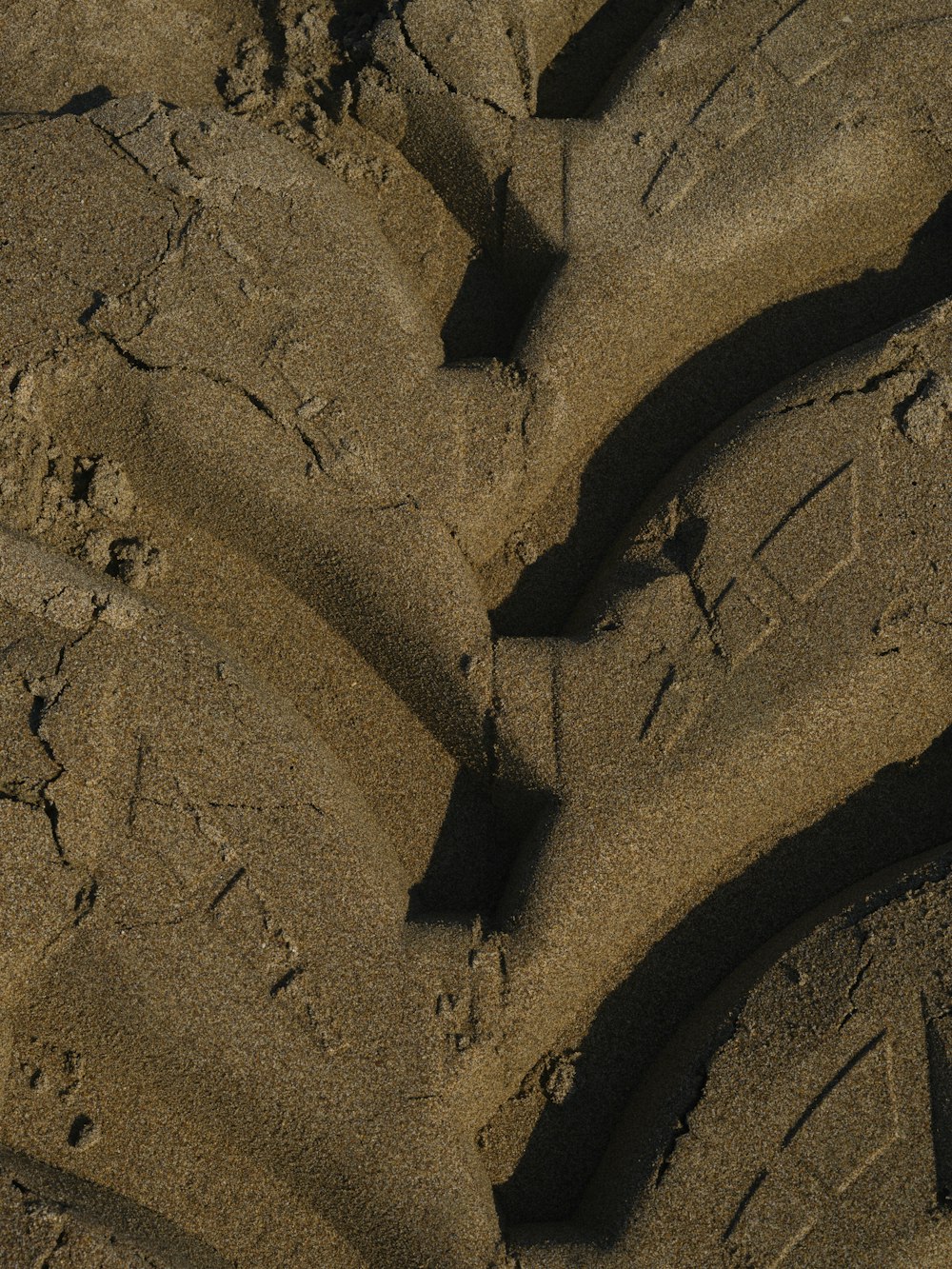 a close up of a tire in the sand