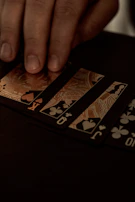 A strategic moment showing a player’s hand hovering over cards with shogi-inspired symbols glowing faintly.