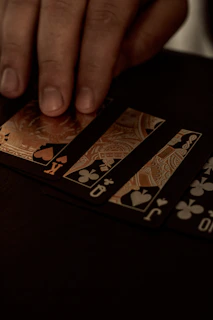 Hands delicately shuffling tarot cards with a hint of shimmering gold dust in the air