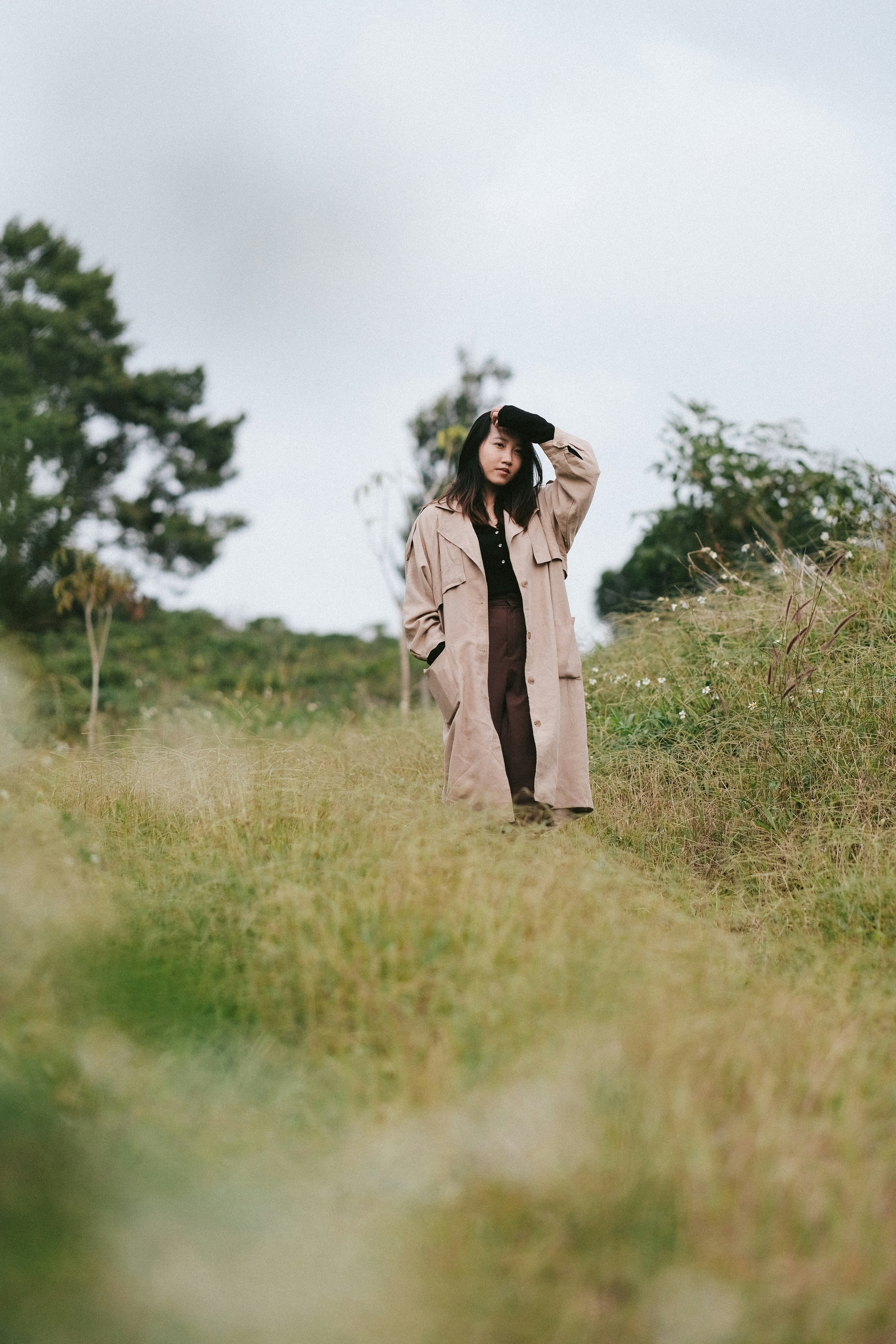 a woman standing in a field with a hat on