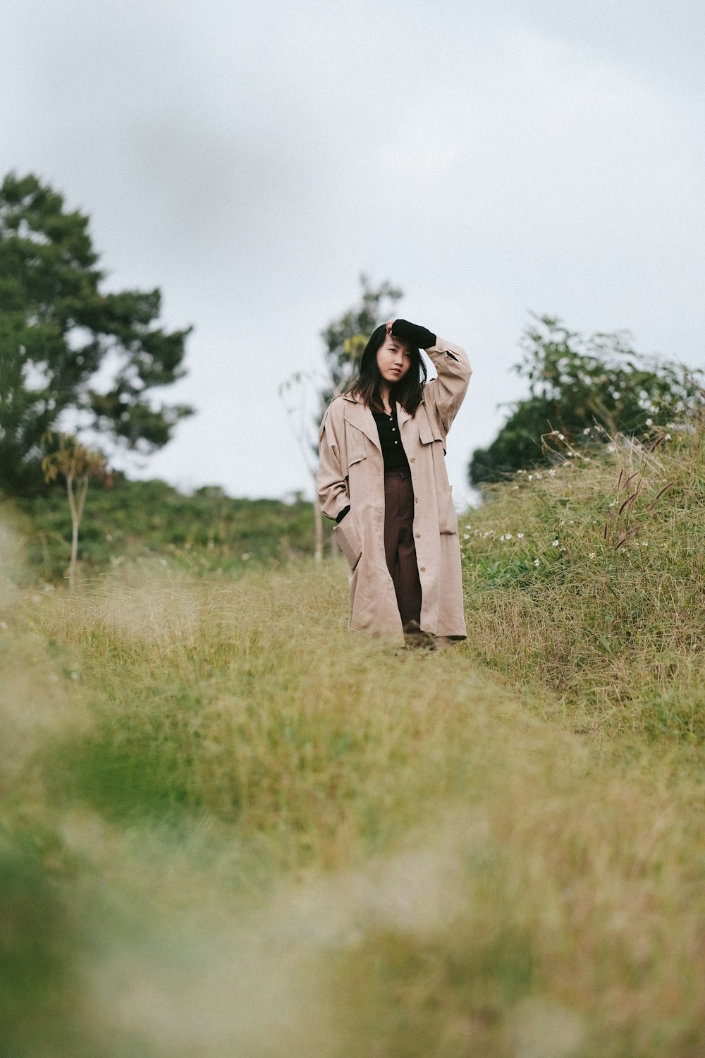 a woman standing in a field with a hat on