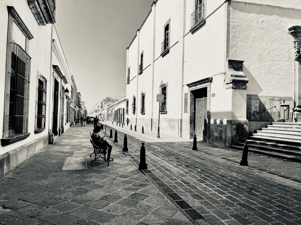 a black and white photo of a person sitting on a bench