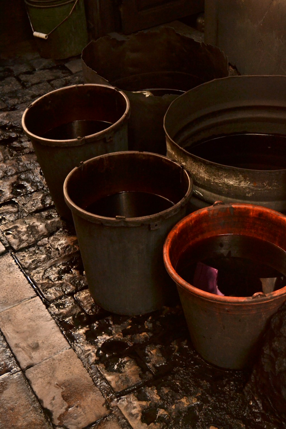 a group of buckets sitting on top of a stone floor