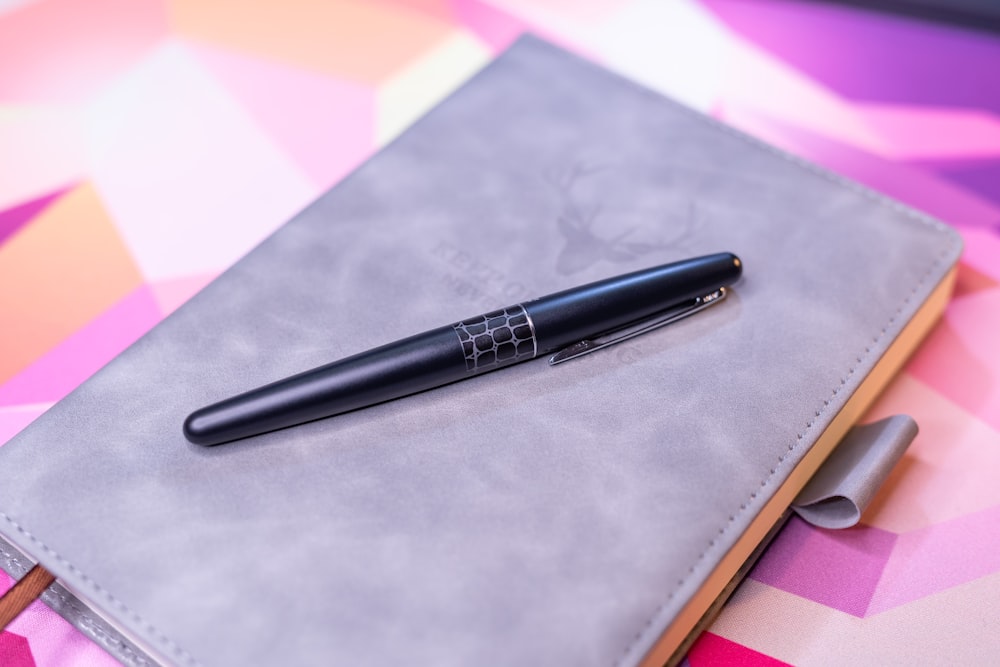 a pen sitting on top of a notebook on a table