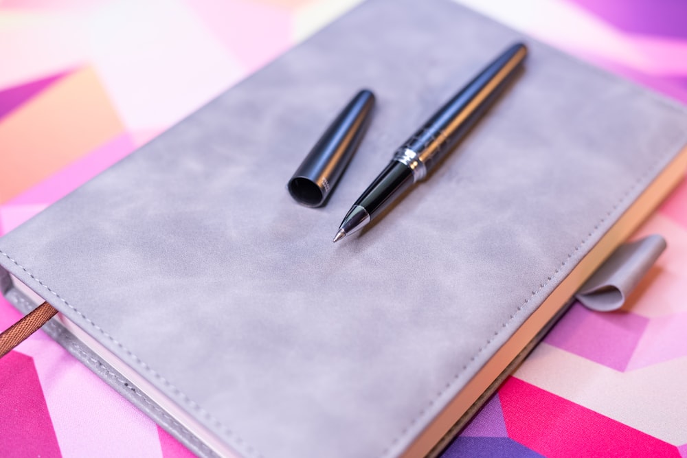 a notebook with a pen on top of it
