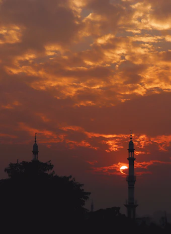 A vibrant sunset view over the Kaaba replica at Nurziarah, with families walking nearby.