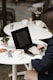 a woman sitting at a table using a laptop computer