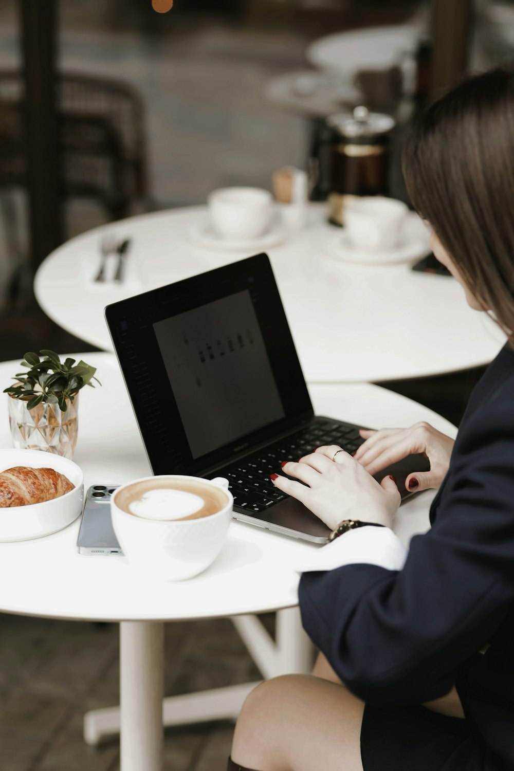 a woman sitting at a table using a laptop computer