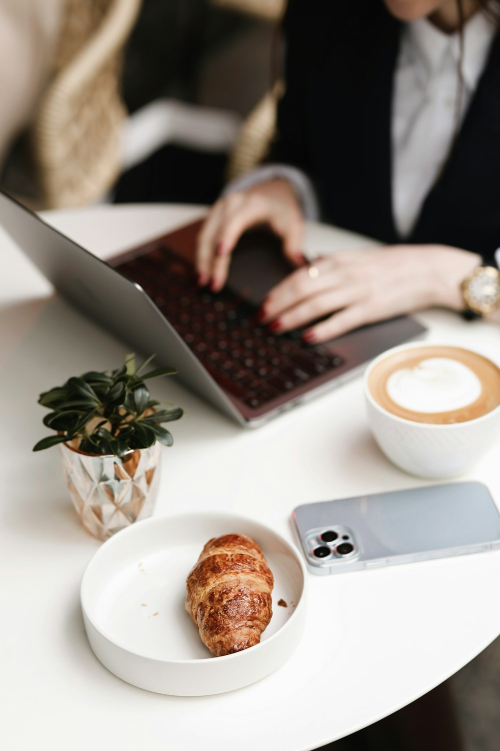 a woman sitting at a table working on a laptop