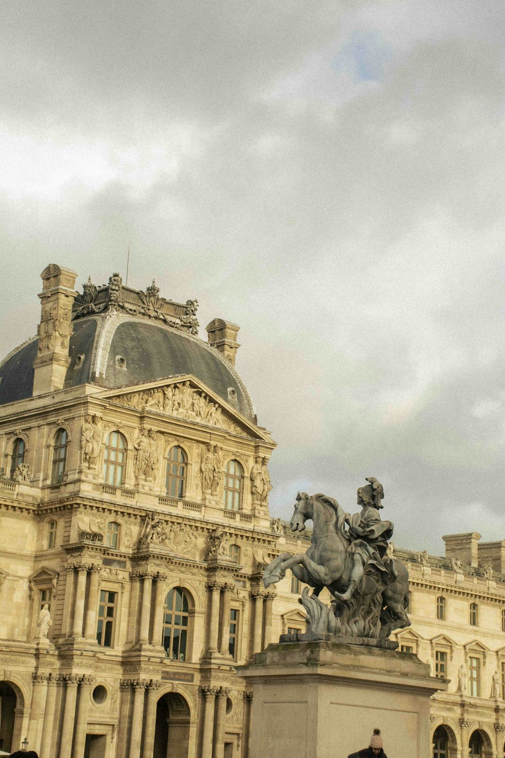 a statue of a man on a horse in front of a building