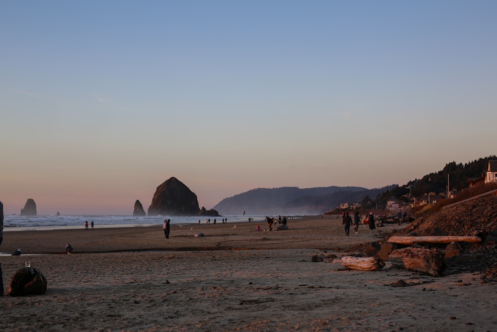 a group of people standing on top of a sandy beach