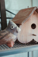 Handmade bamboo chick figurines displayed on a rustic wooden shelf.