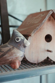 Handmade bamboo chick figurines displayed on a rustic wooden shelf.