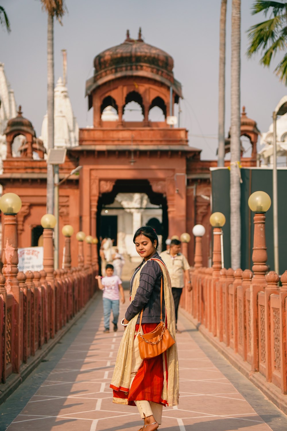 a woman standing on a brick walkway in front of a building