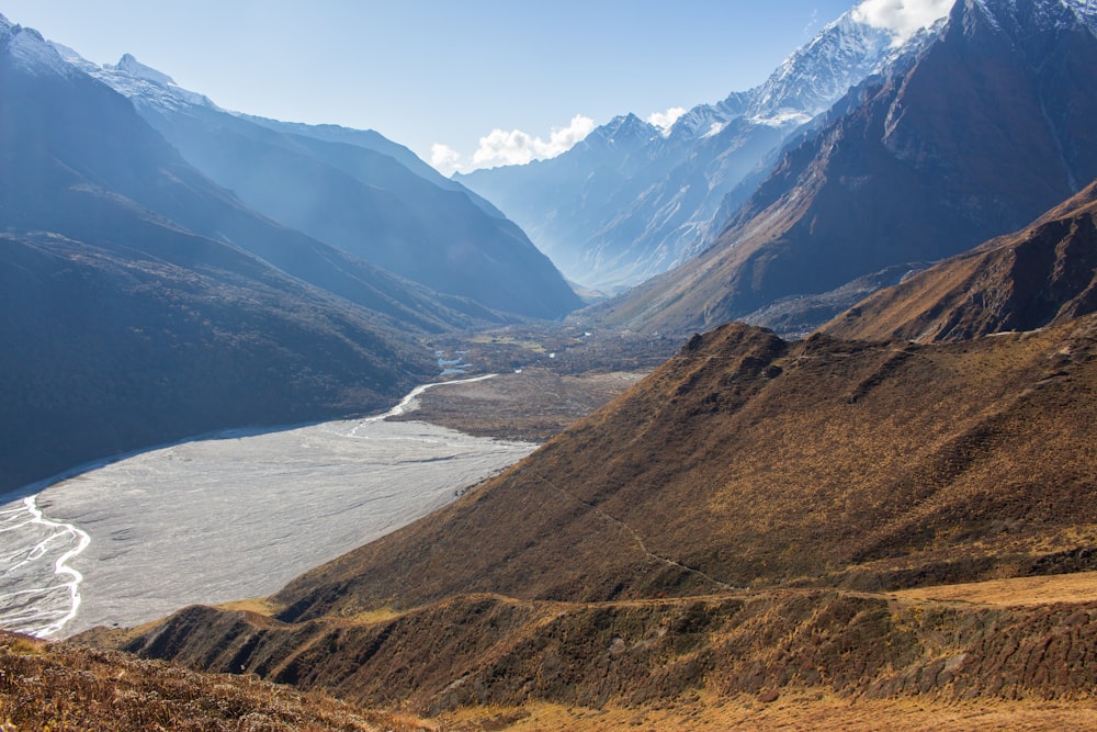 a river running through a valley surrounded by mountains