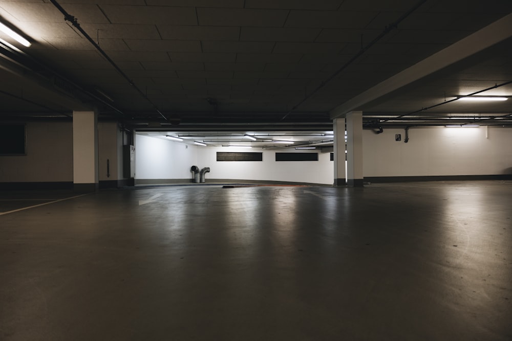 an empty parking garage with a person sitting on the floor