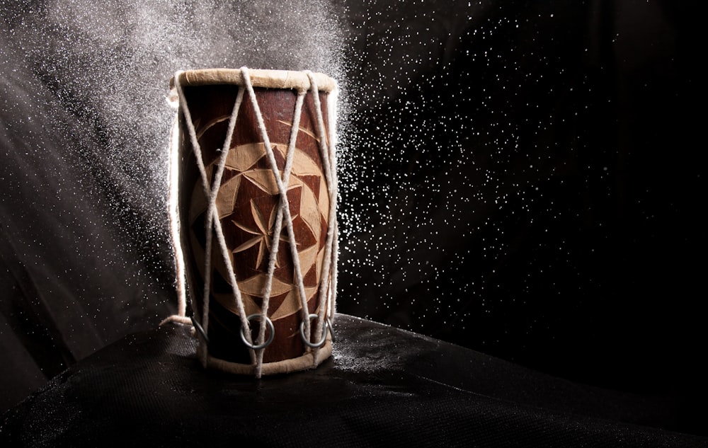 a drum with a string around it on a black background