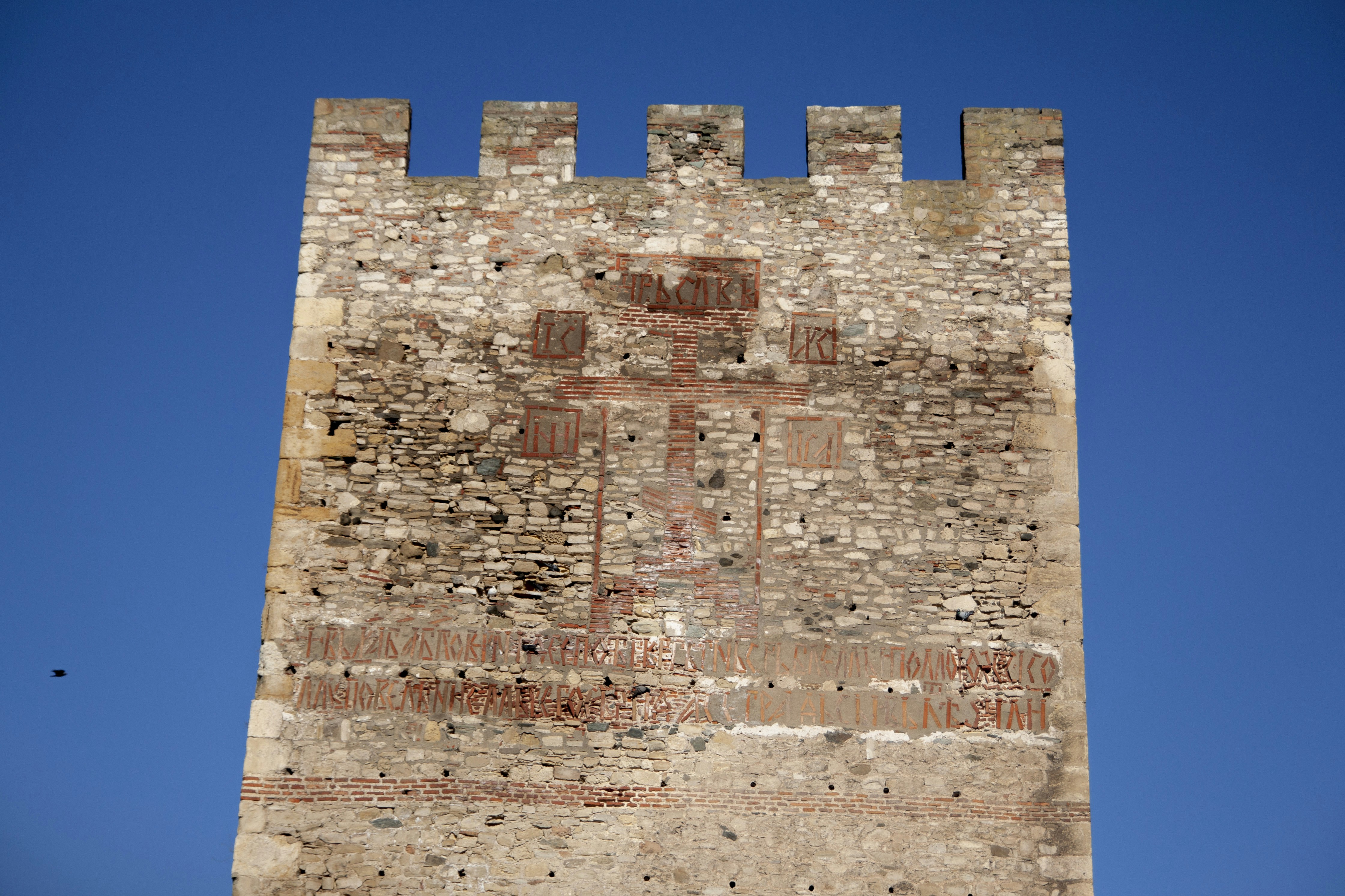 a very tall brick tower with a clock on it's side