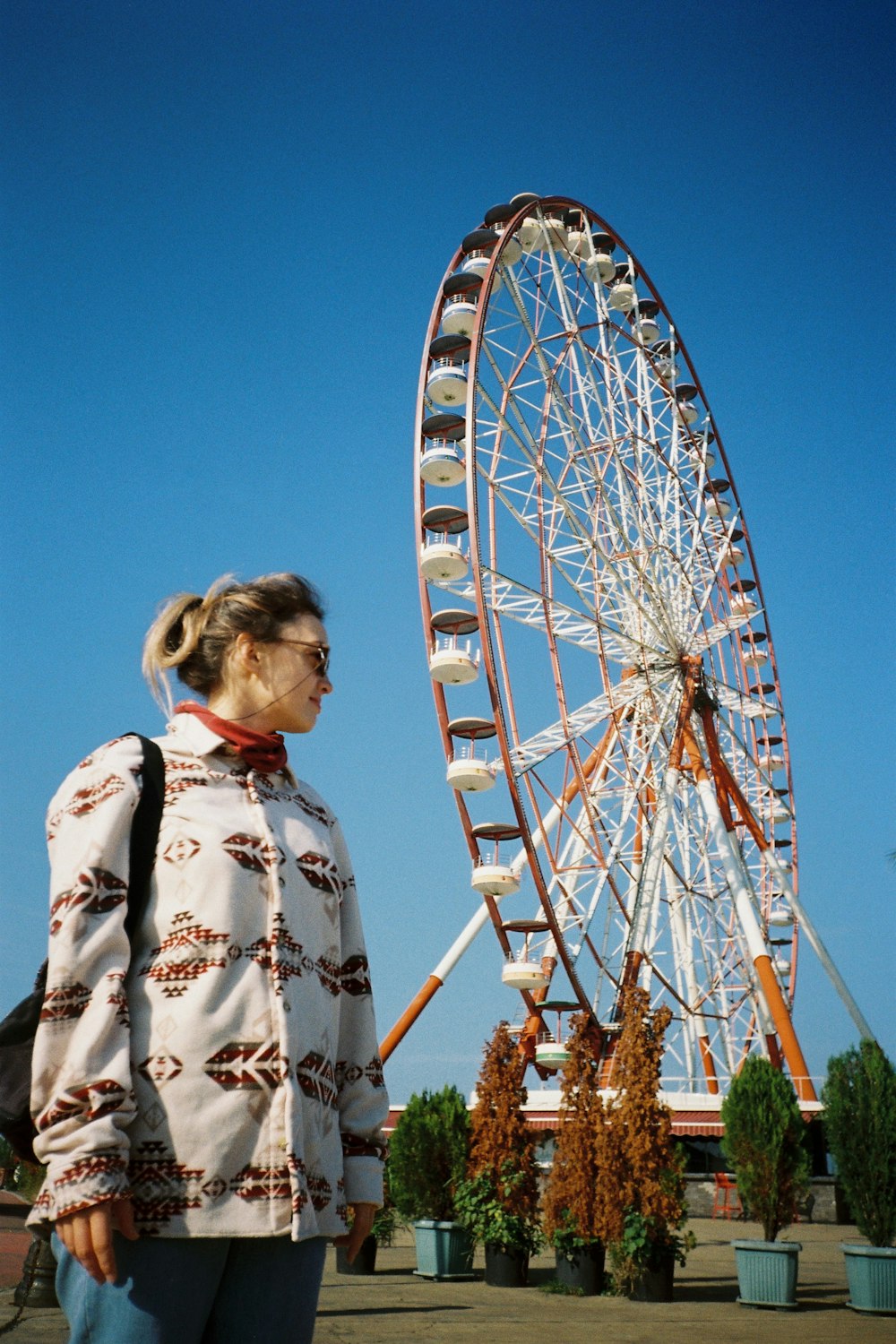 a woman standing in front of a ferris wheel