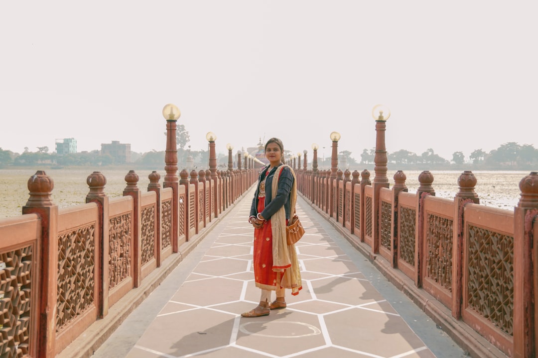 a woman standing on a bridge over a body of water,