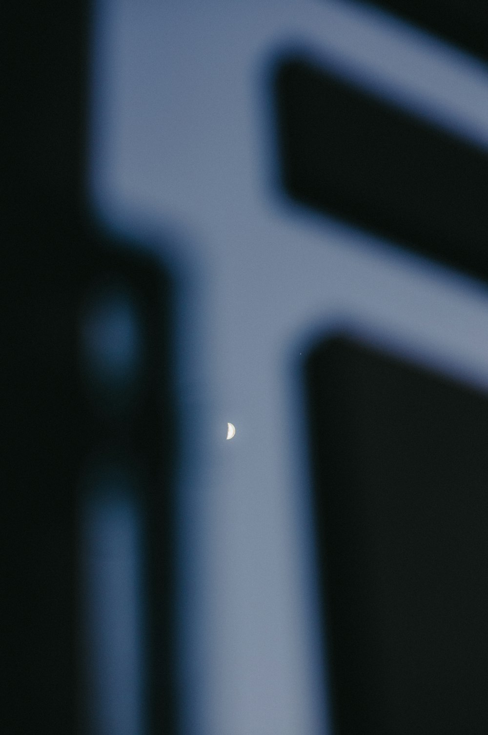 the moon is seen through the window of a building