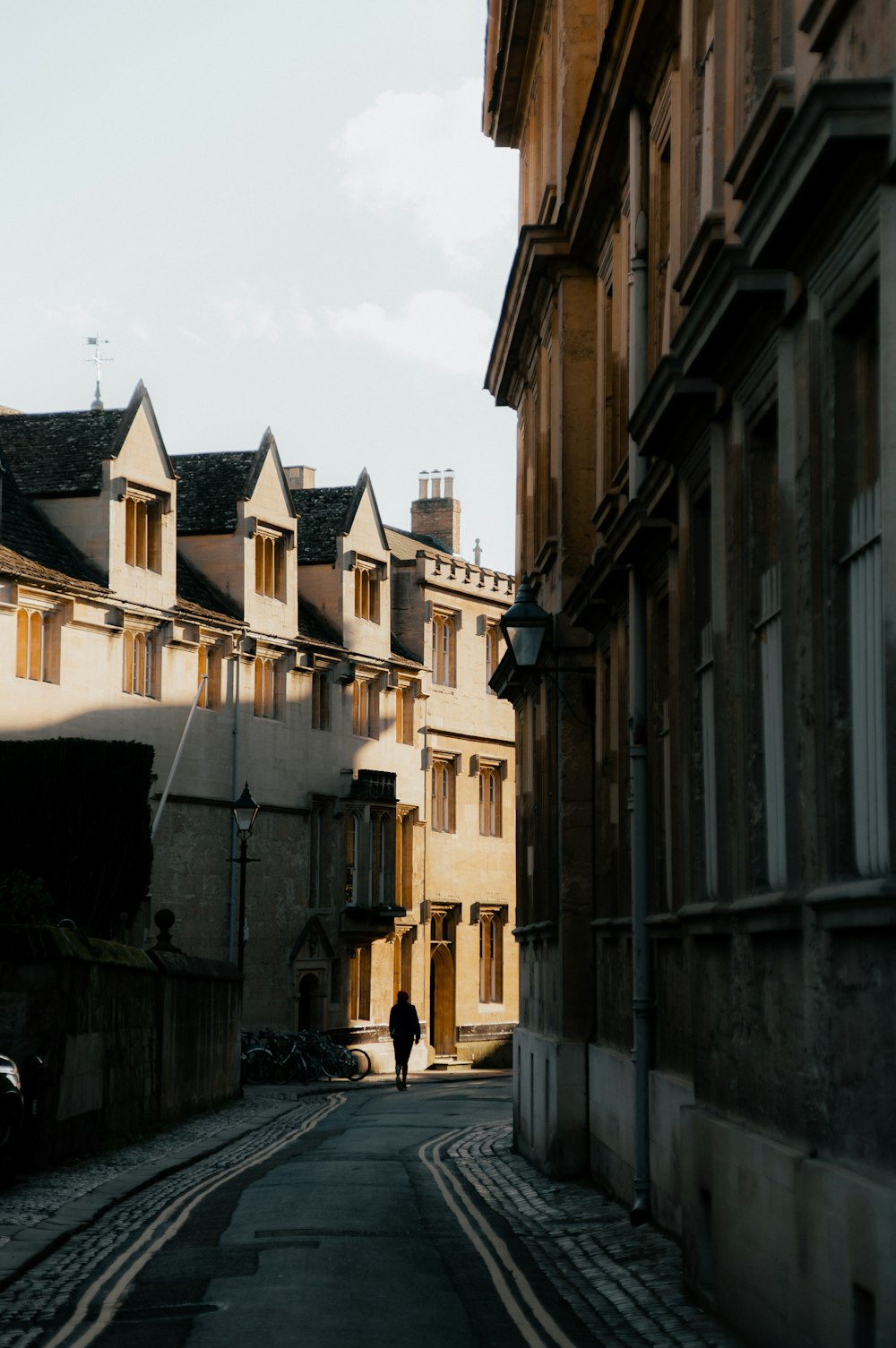 a person walking down a street next to tall buildings