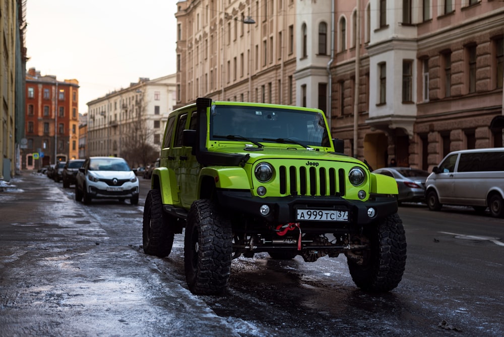 a bright green jeep is parked on the side of the road