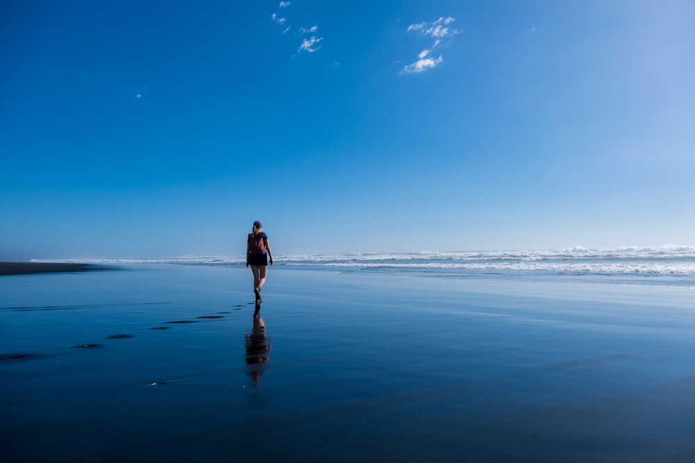 a person walking on a beach near the ocean