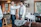 A stylish young man receiving guidance from a mentor in a bright, modern studio setting.