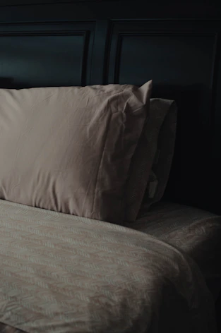 a bed with a brown comforter and two pillows