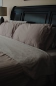 a bed with a brown comforter and pillows