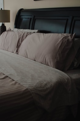 a bed with a brown comforter and pillows