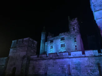 Evening view of a historic castle illuminated against the desert sky.