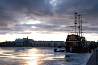 A weathered vintage postcard depicting a 1920s steamship docked at a foggy harbor, its edges softened by time.