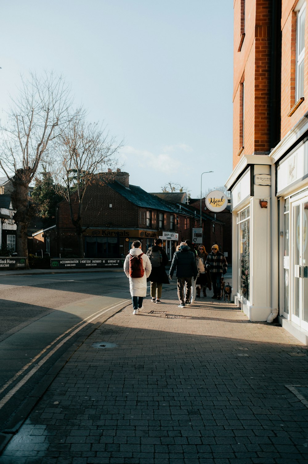 a group of people walking down a street next to tall buildings