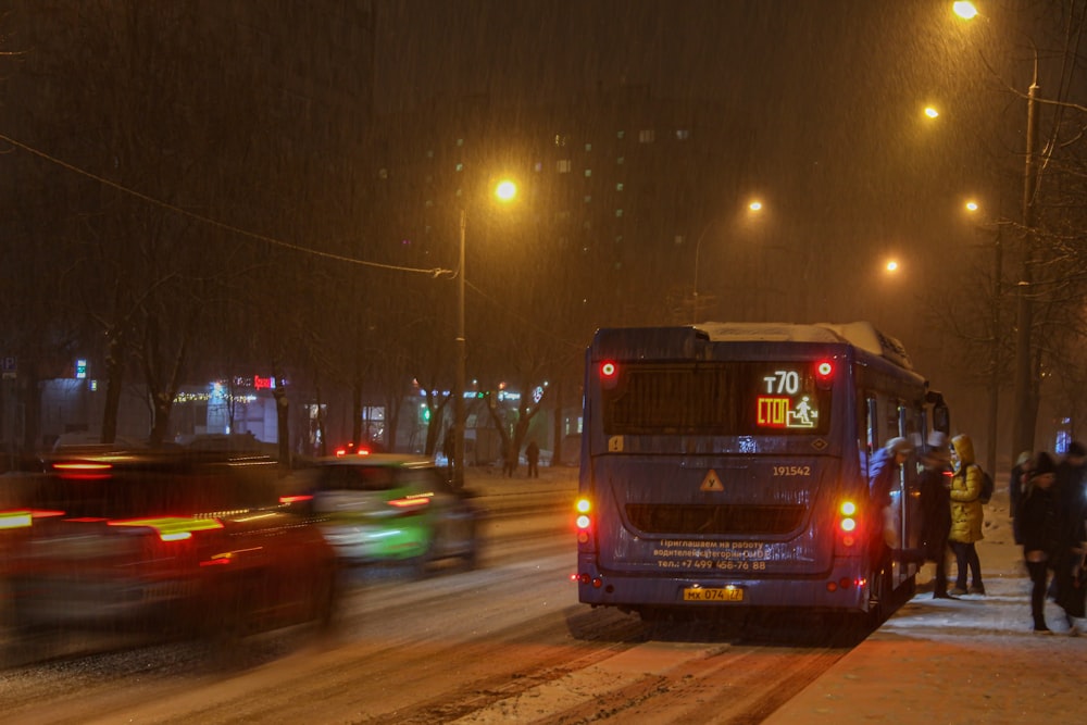 a bus driving down a snowy street at night