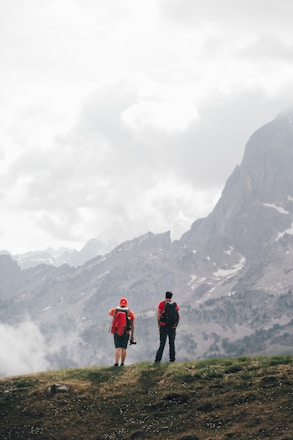 a couple of people standing on top of a hill