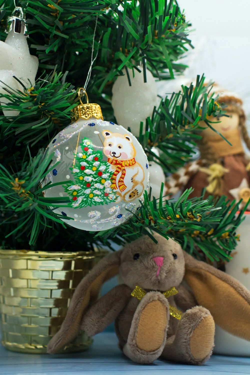 a stuffed animal sitting next to a christmas tree