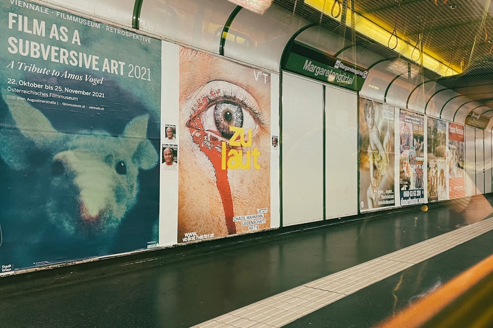 a subway train with posters on the side of it