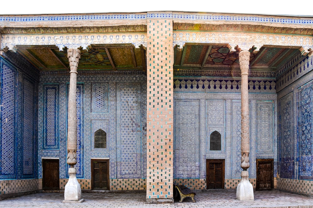 a blue and white building with columns and a bench