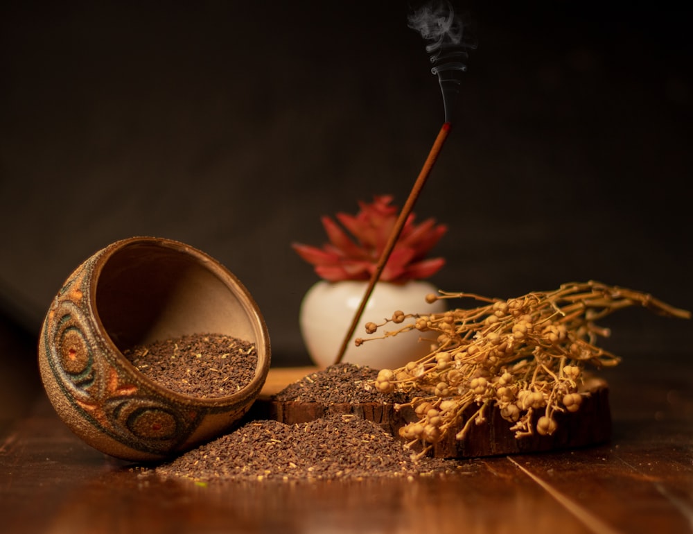 a wooden table topped with a bowl filled with dirt