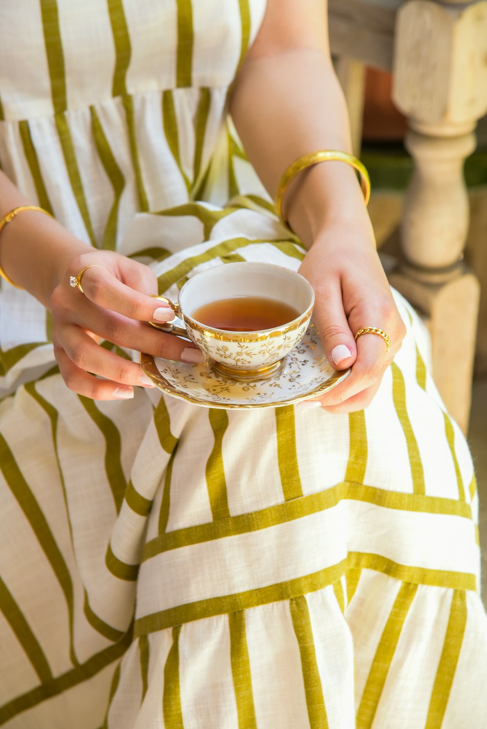 a woman holding a cup of tea in her hands