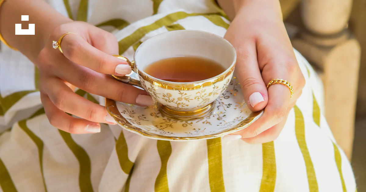 A woman holding a cup of tea in her hands photo – Free Fashion Image on ...