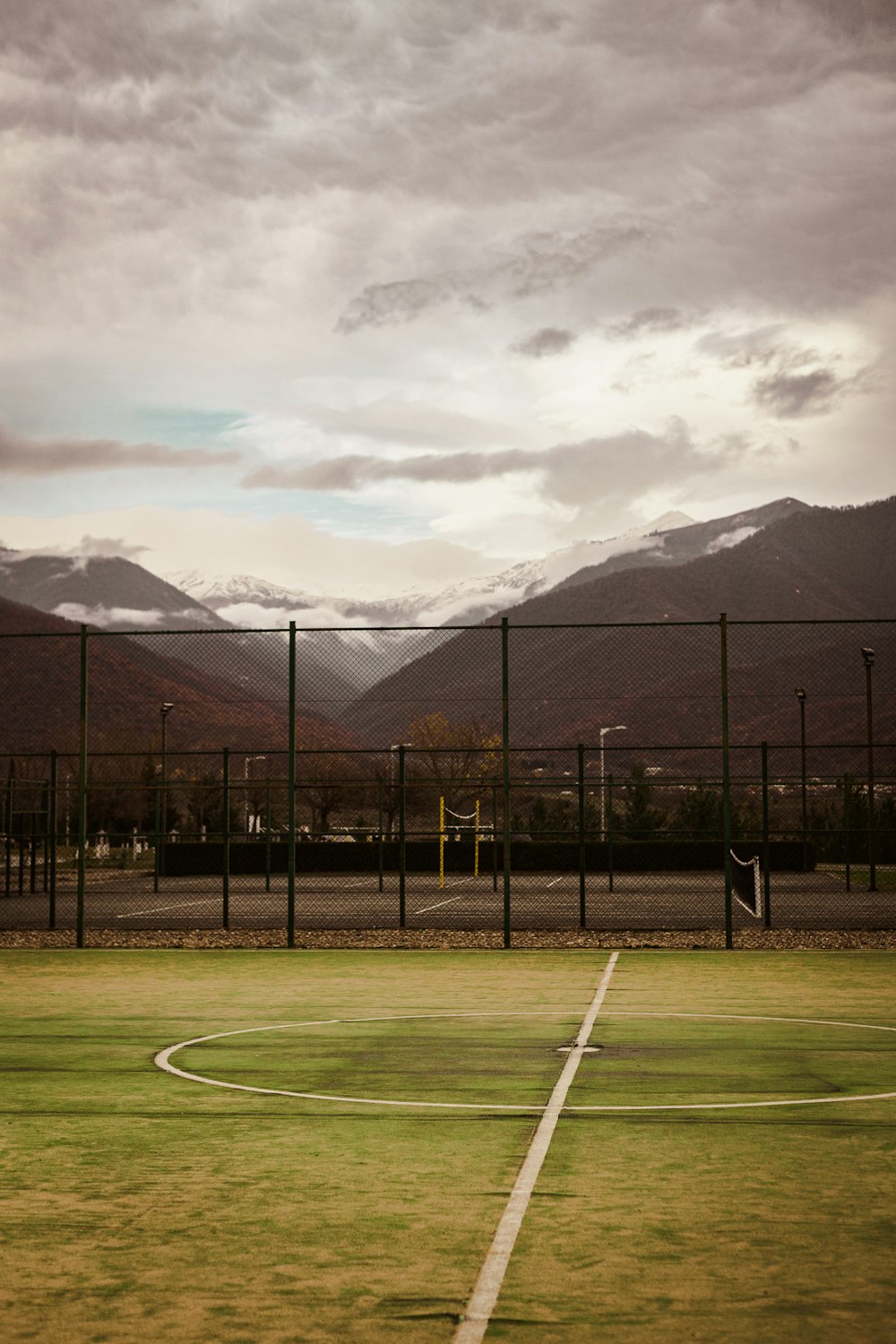a tennis court with mountains in the background