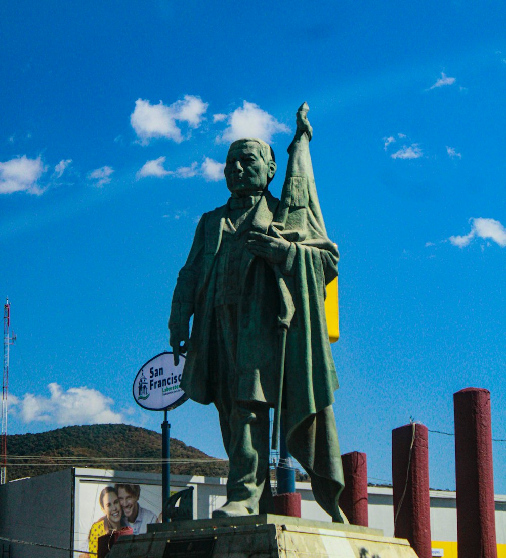 una estatua de un hombre sosteniendo un cartel frente a un edificio