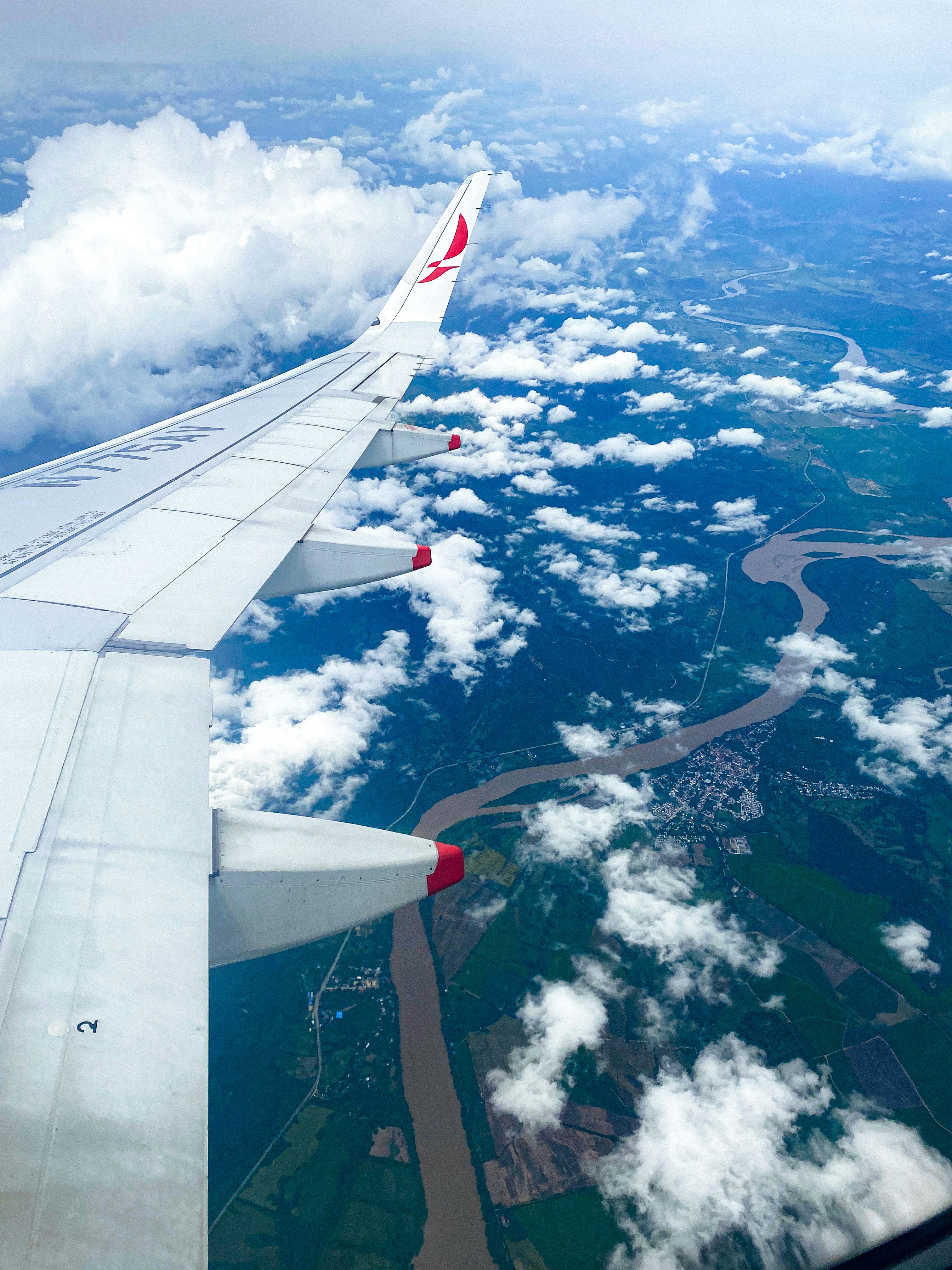 l’aile d’un avion survolant une rivière