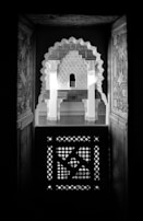 Close-up detail of the smooth black wood finish and intricate mosque arch patterns engraved subtly on the frame edges.