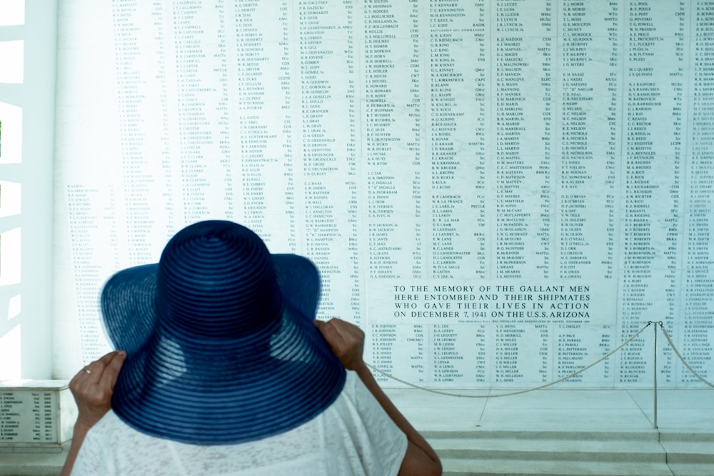 Une femme portant un chapeau bleu devant un mur