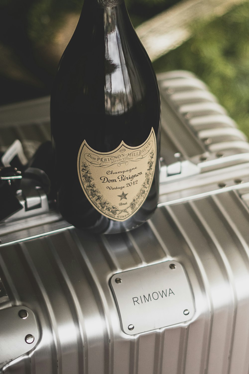 a bottle of wine sitting on top of a suitcase