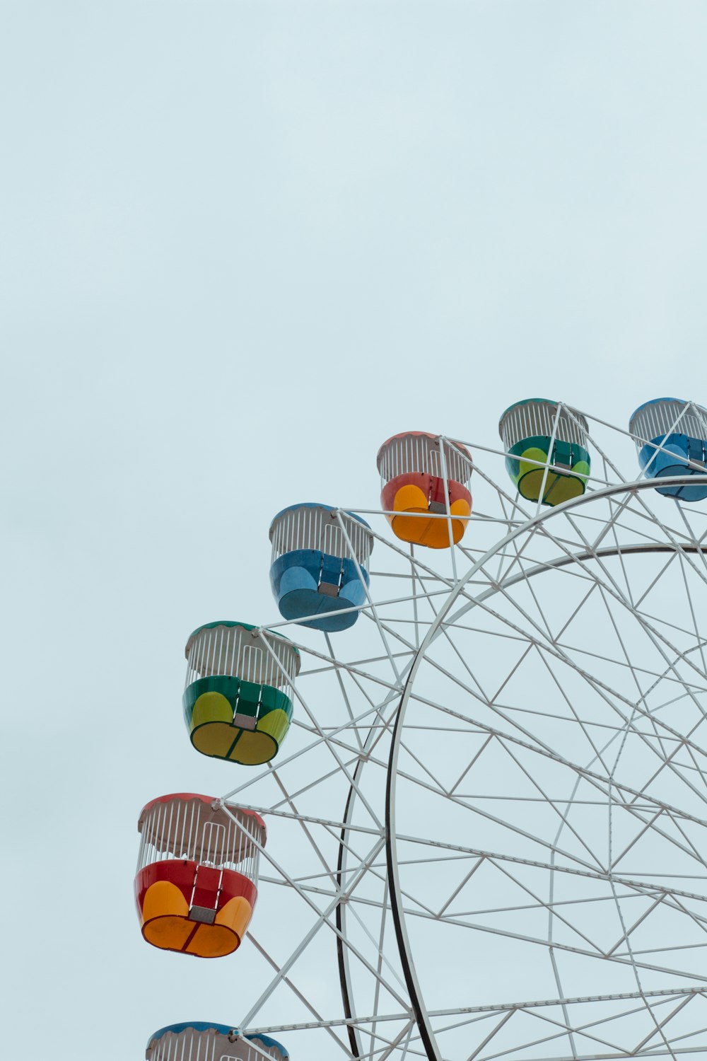 a ferris wheel with colorful seats on a cloudy day